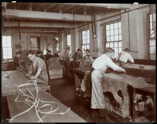 Vue intérieure des hommes et des femmes travaillant le cuir à la New York Leather Belting Co., New York, 1906